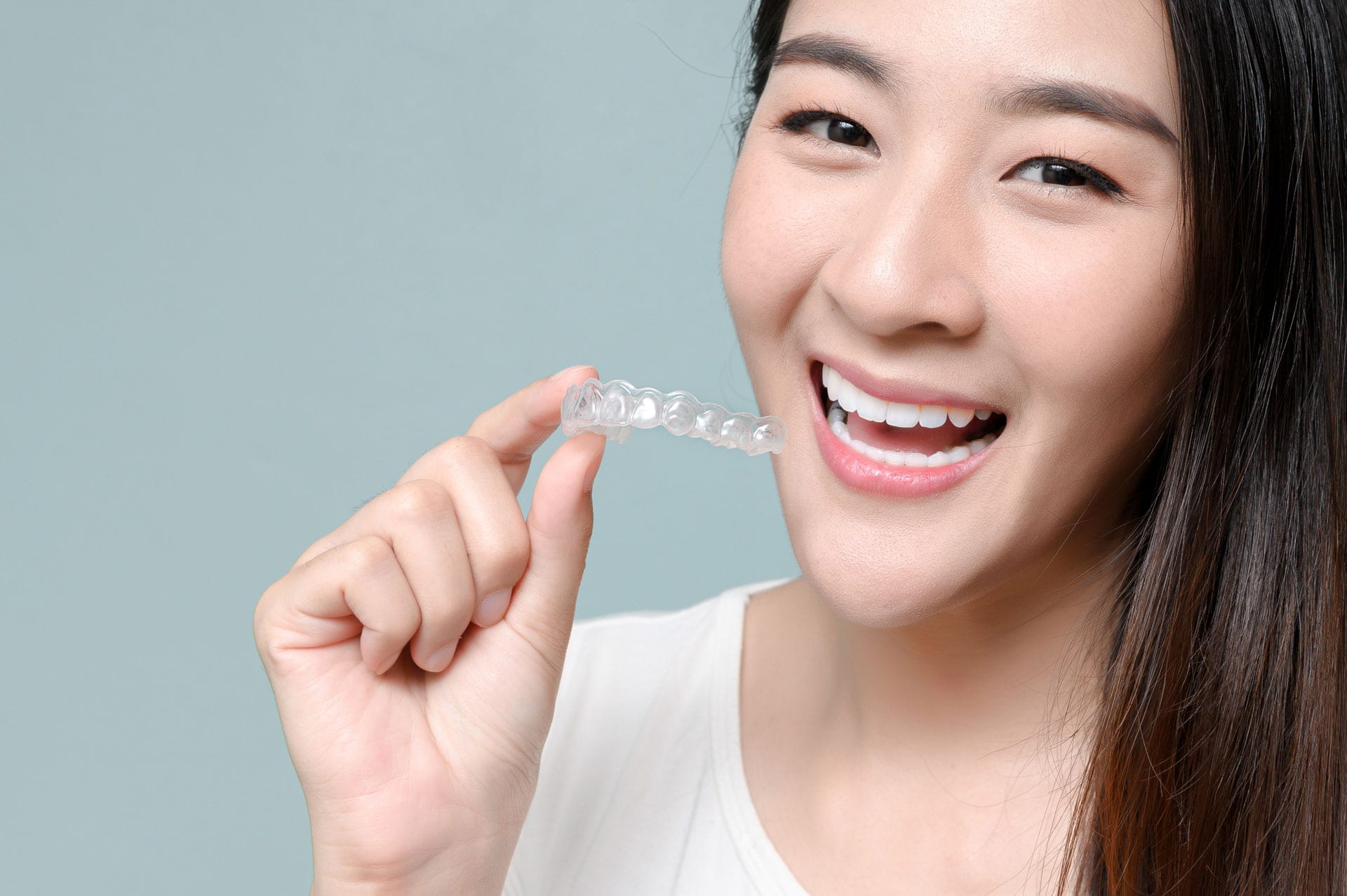 asian lady smiling with Invisalign clear aligner