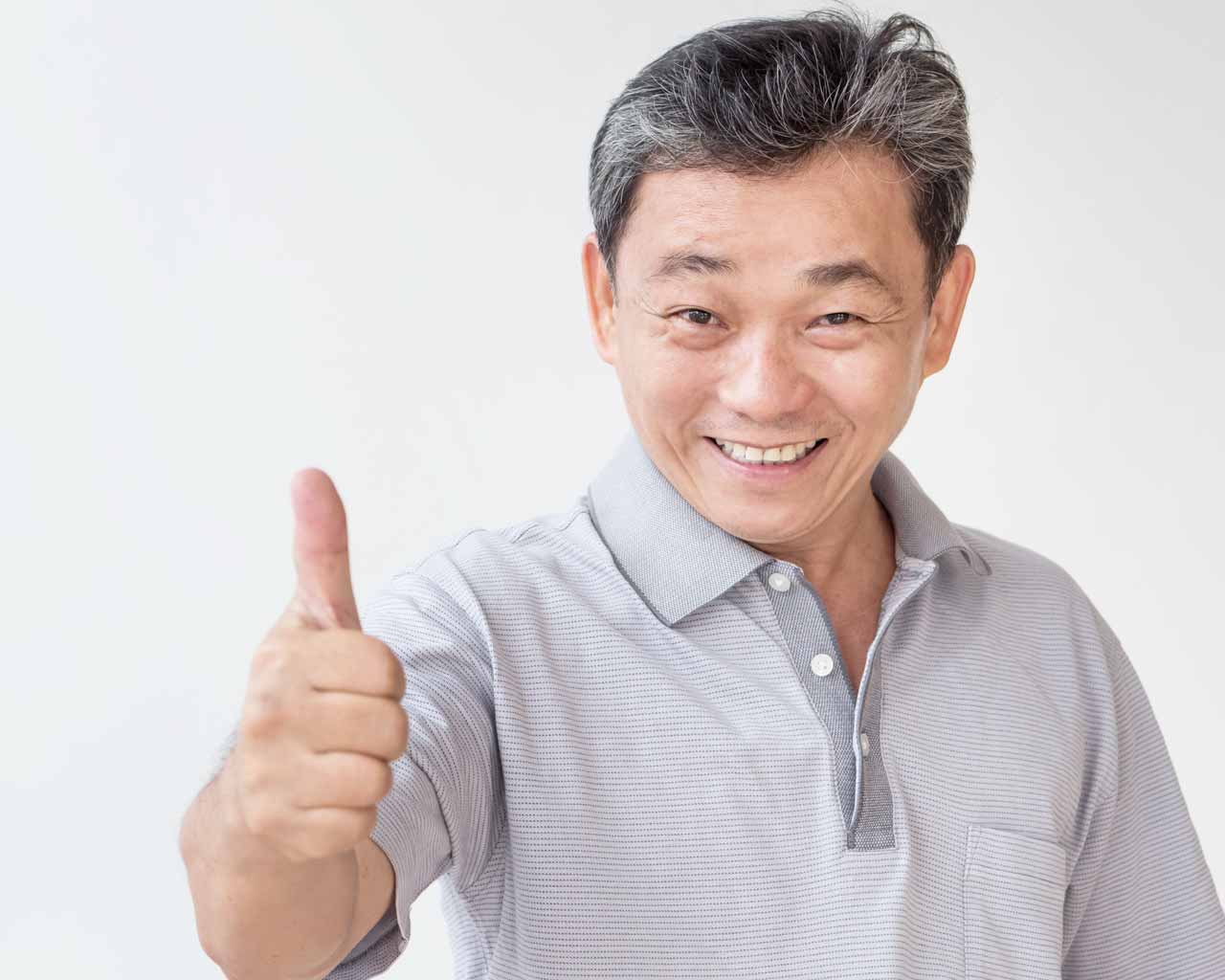 Happy asian man posing with his dental implanted teeth in Singapore