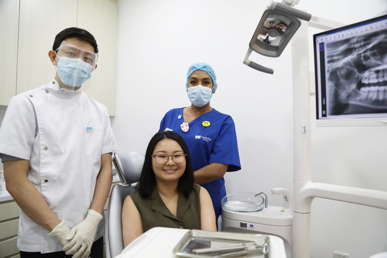 Dr Joshua Chong, Dentist posing in the clinic with a patient and a dental assistant | Invisalign Singapore | Invisalign Treatment Singapore