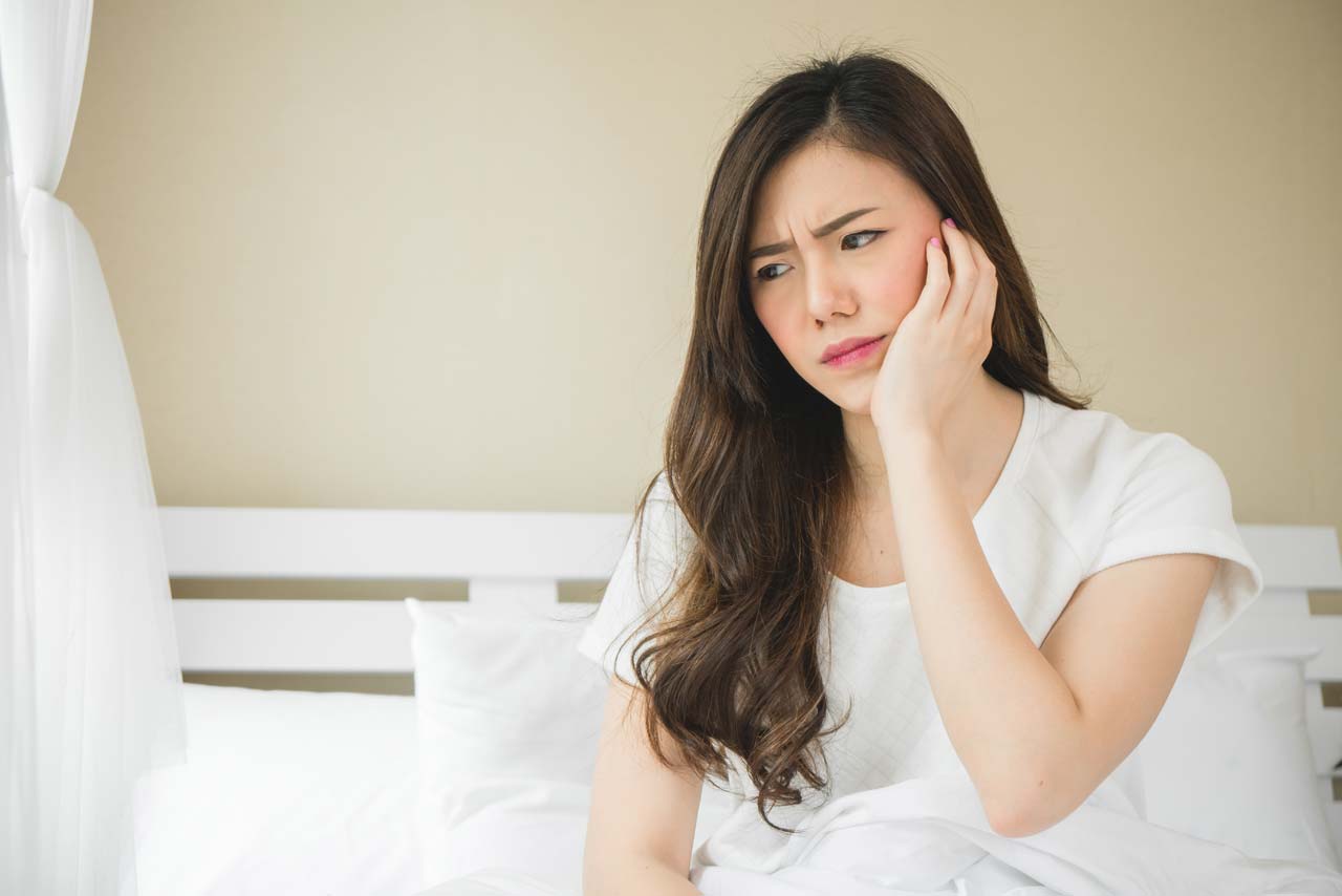 woman suffering from impacted wisdom teeth