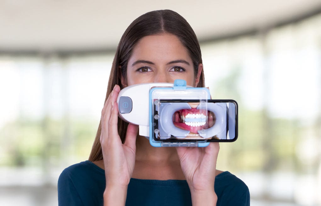 Woman-using-Dental-Monitoring-ScanBox Woman using dental monitoring scanbox to scan and track her progress with Invisalign treatment