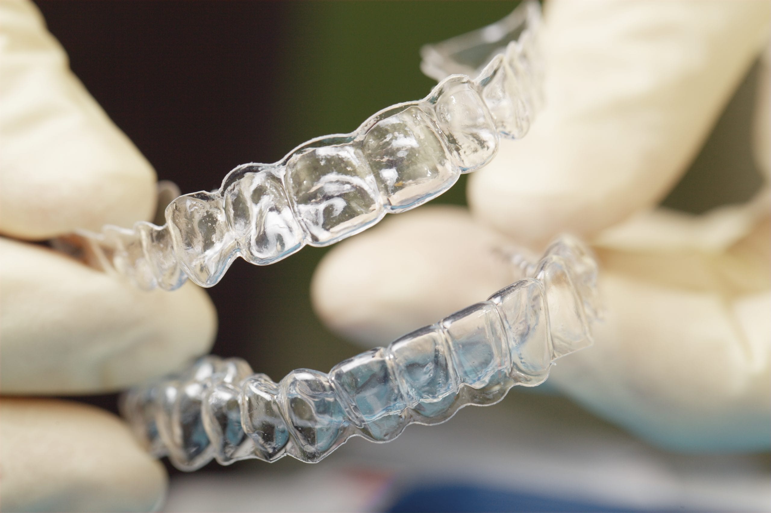 Doctors hands holding silicone mouth guard Getting a Clear plastic retainer in Singapore