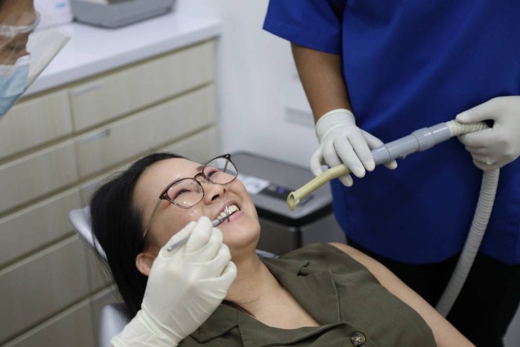 happy dental patient undergoing Invisalign aligner fitting
