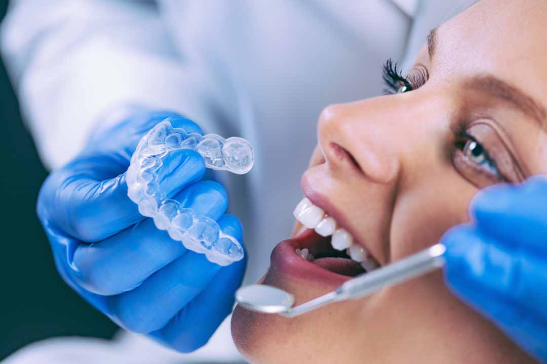 Dentist teaching patient how to use take home teeth whitening kit in Singapore