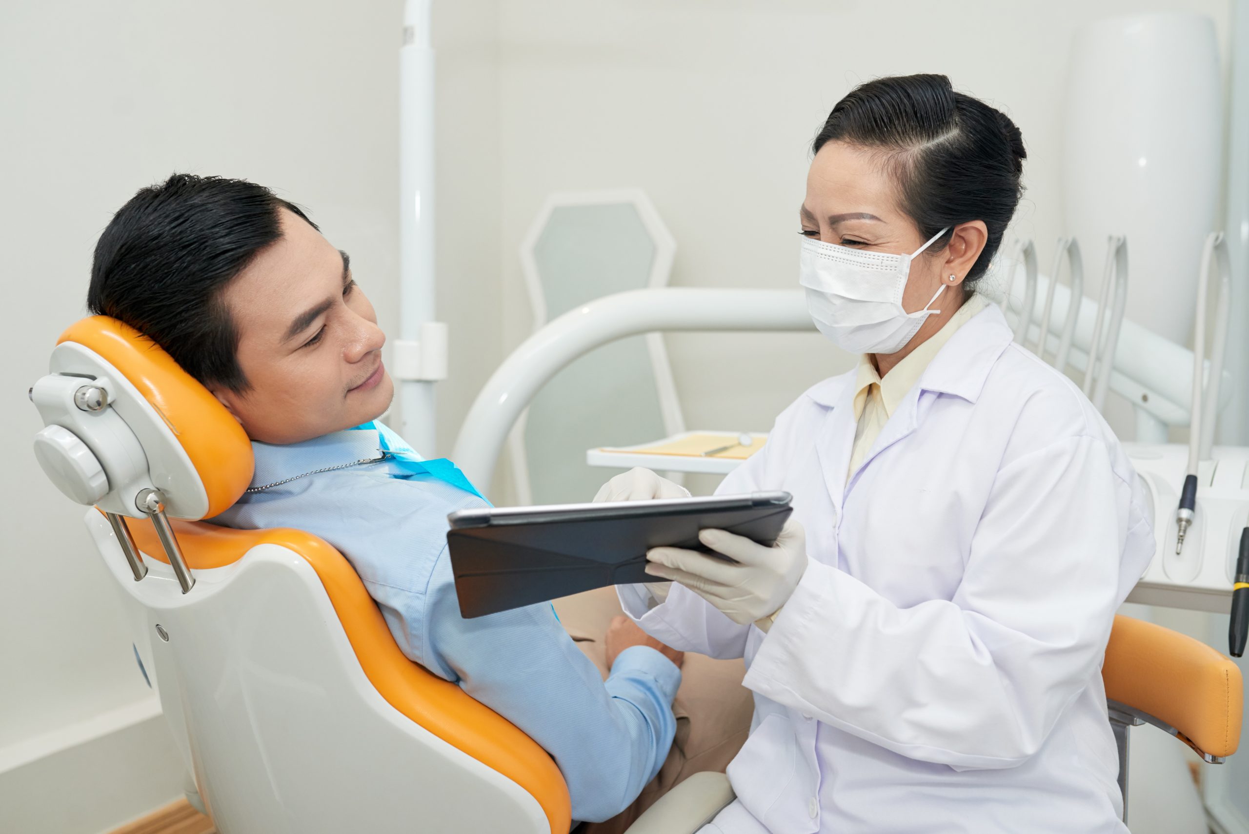 Dentist discussing a jaw x-ray with a patient before a tooth extraction in Singapore