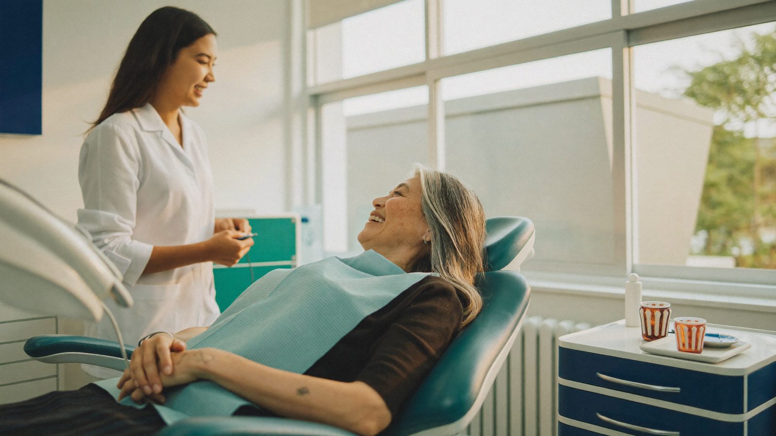 Senior dental patient smiling in the chair at a Singapore clinic while her dentist explains Flexi-MediSave 2026 subsidies