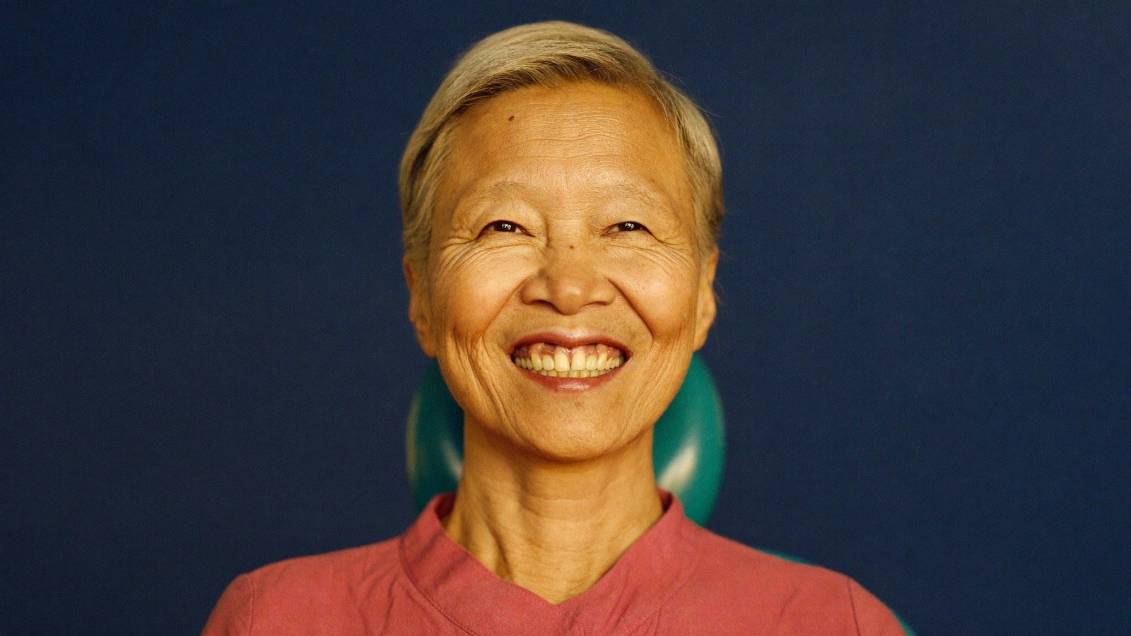 Smiling senior CHAS cardholder at a NoFrills Dental clinic in Singapore