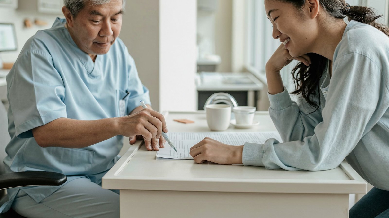 Dentist going through a written dental treatment plan and its cost with a patient at a Singapore dental clinic