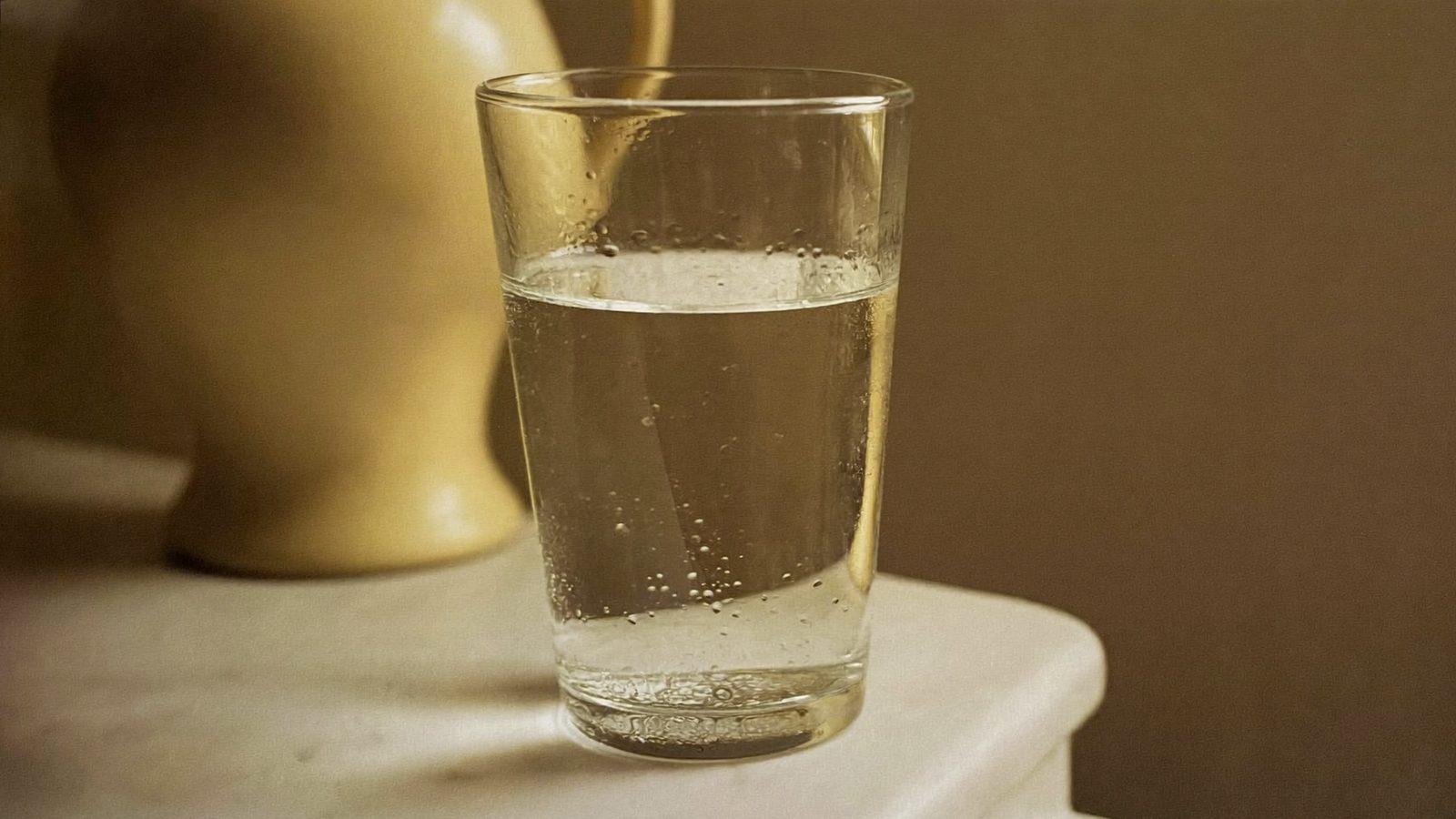 Glass of water on a counter, hydration keeps saliva flowing and breath fresher