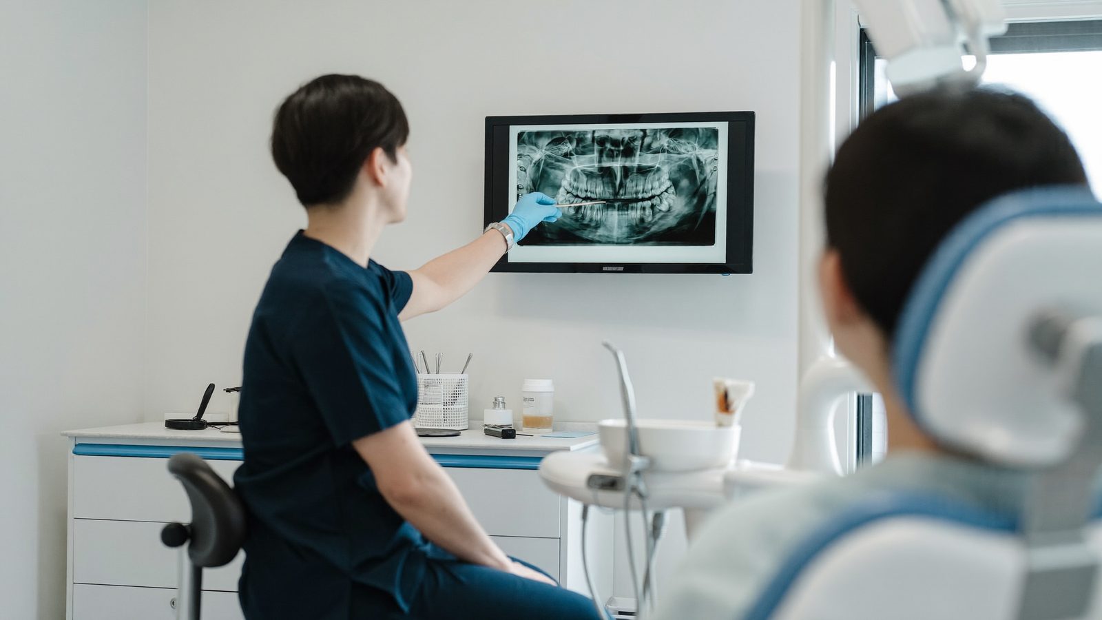 A dentist examining a patient during an emergency dental appointment at a NoFrills Dental clinic