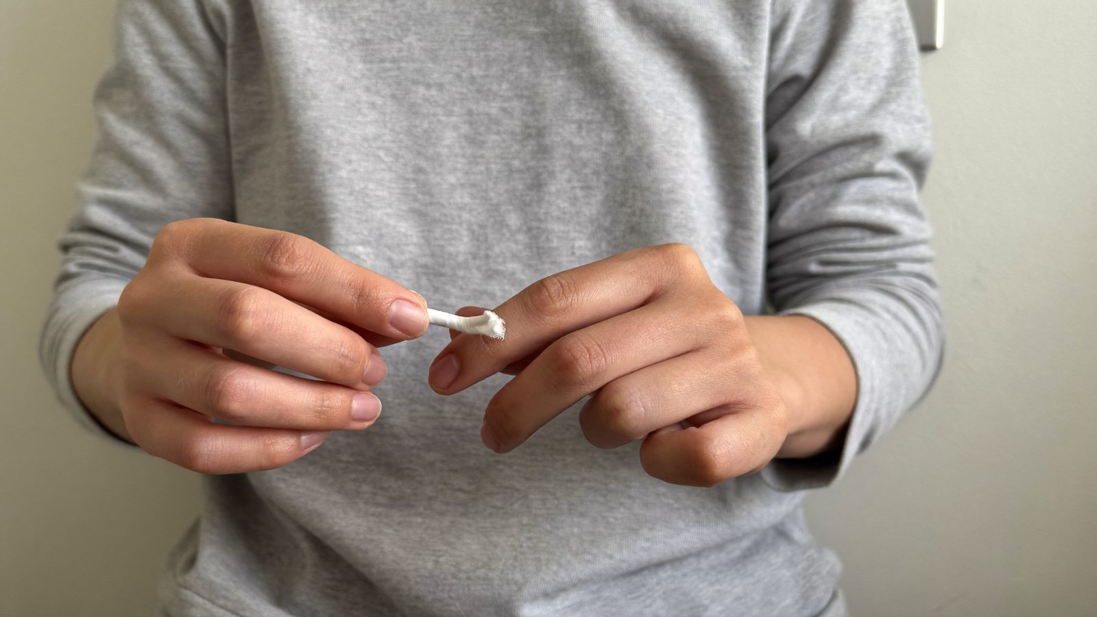 Hands holding dental floss ready to clean between the teeth
