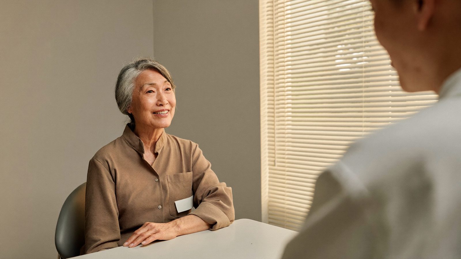 Dentist explaining gum health to an older Singaporean patient at a consultation table